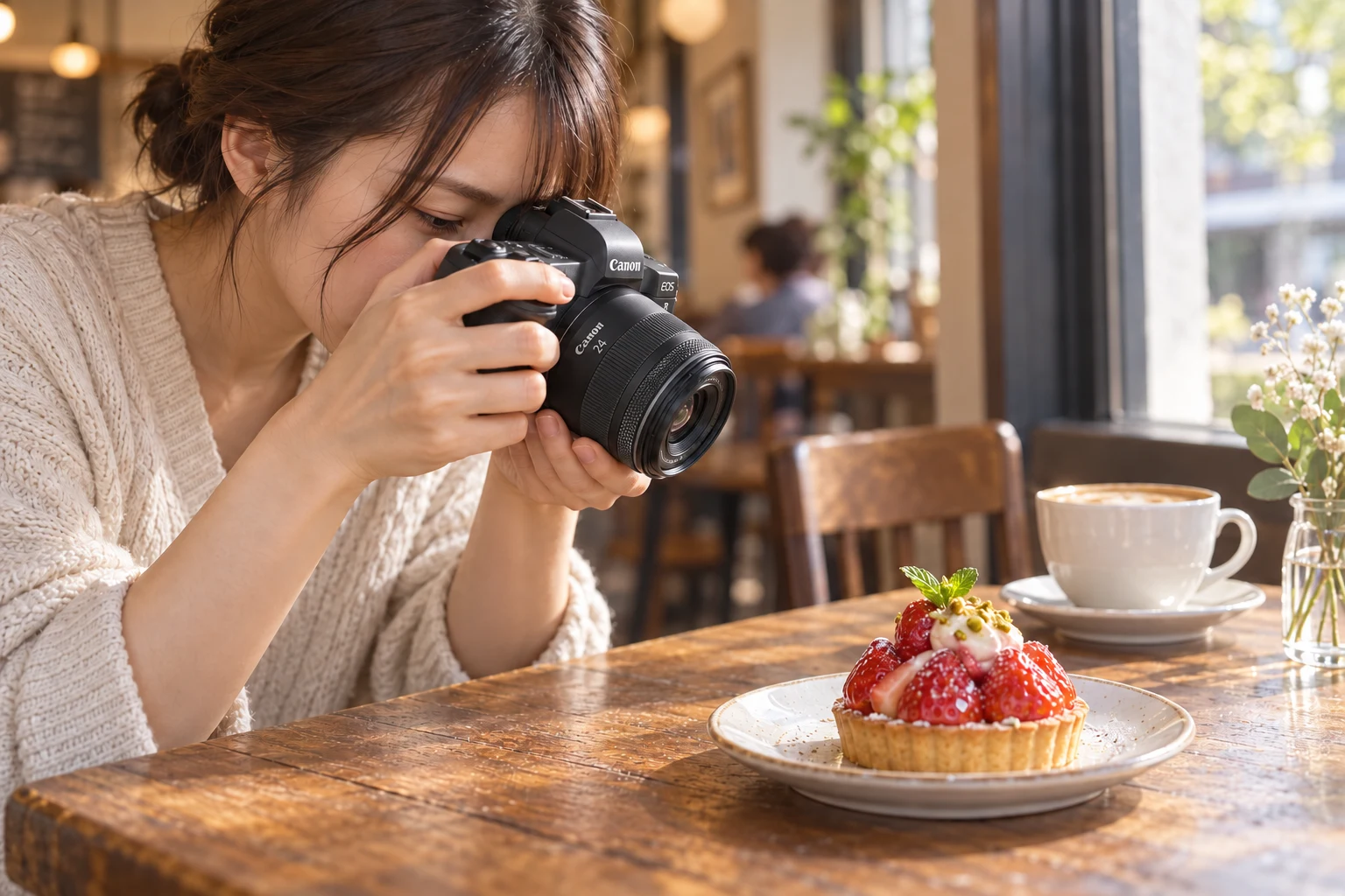 カフェのテーブルでRF24mm付きカメラをタルトへ向ける女性