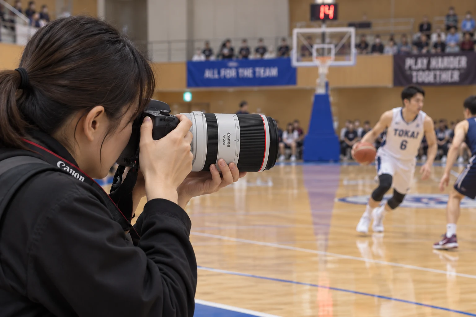 屋内のバスケットボール選手へRF70-200mm F2.8を向ける撮影者