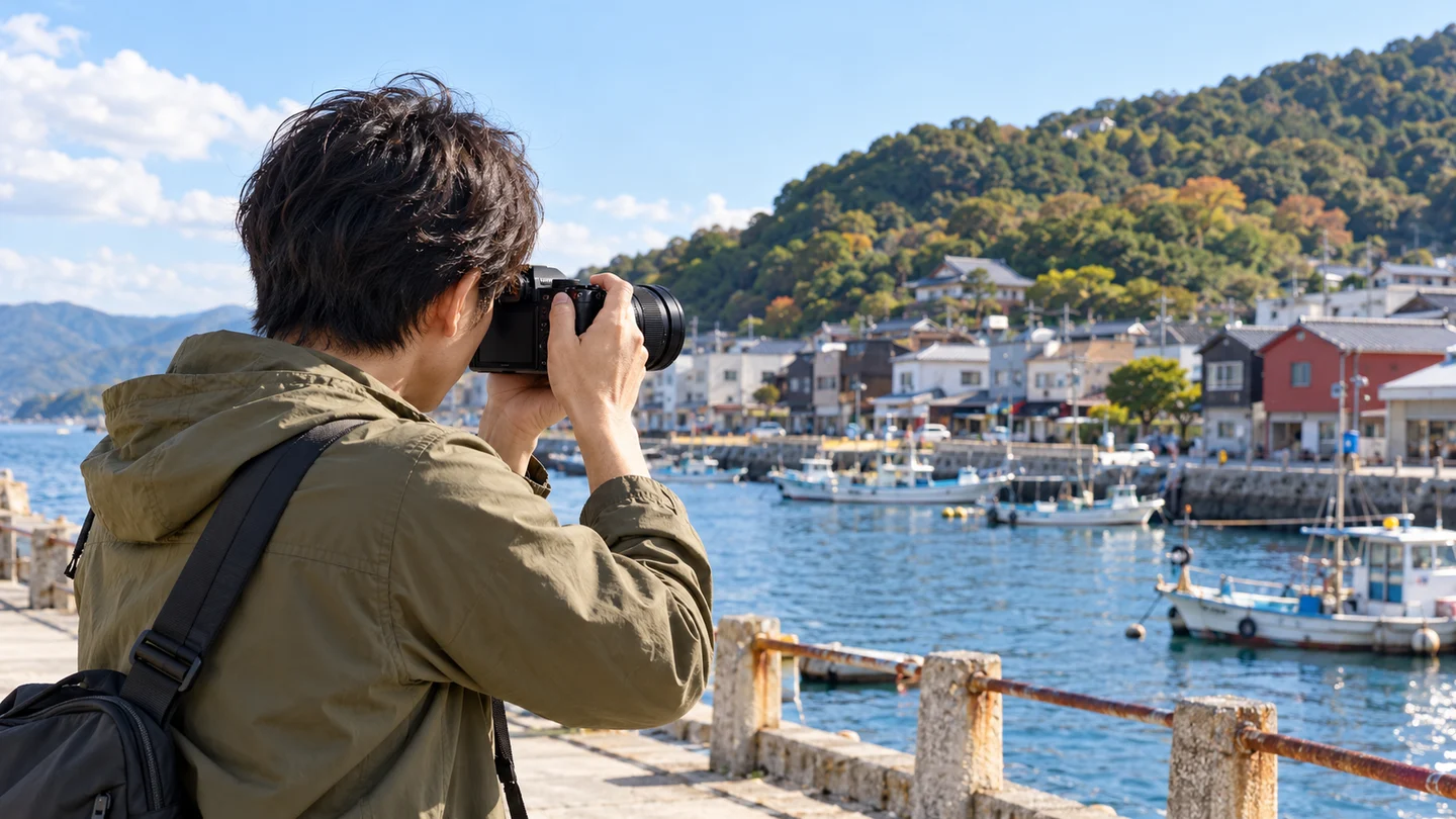 G99M2と14-140mm IIを港の建物や船へ向け、ファインダーを覗いて撮影する旅行者