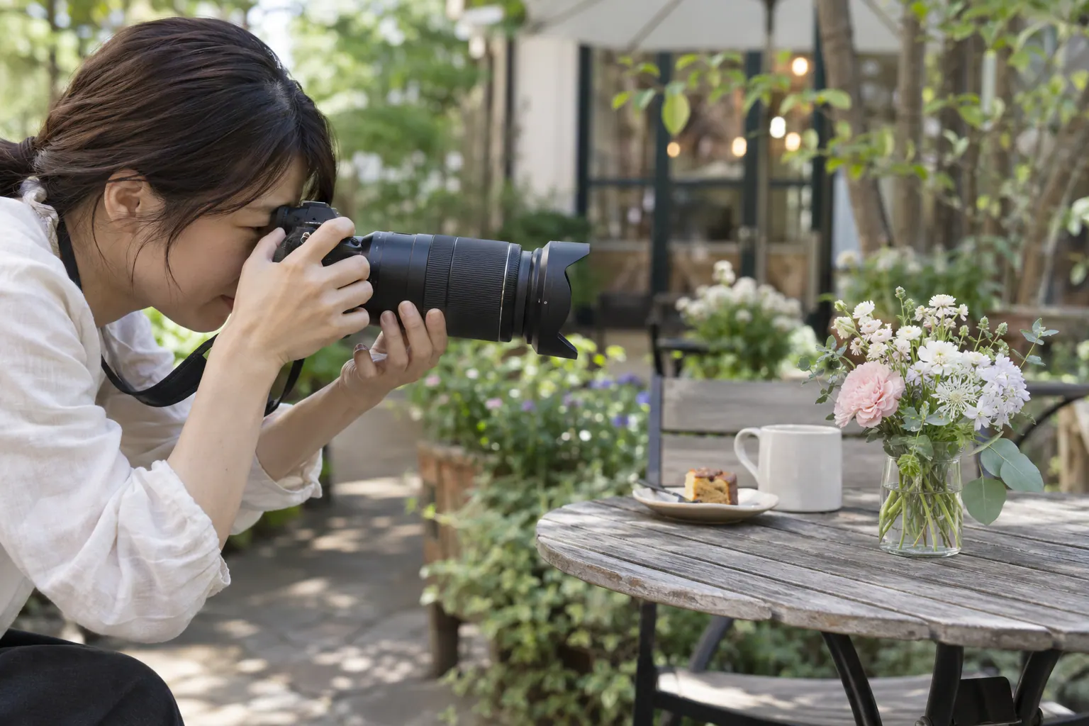 庭のカフェでテーブルの花へカメラを向ける場面