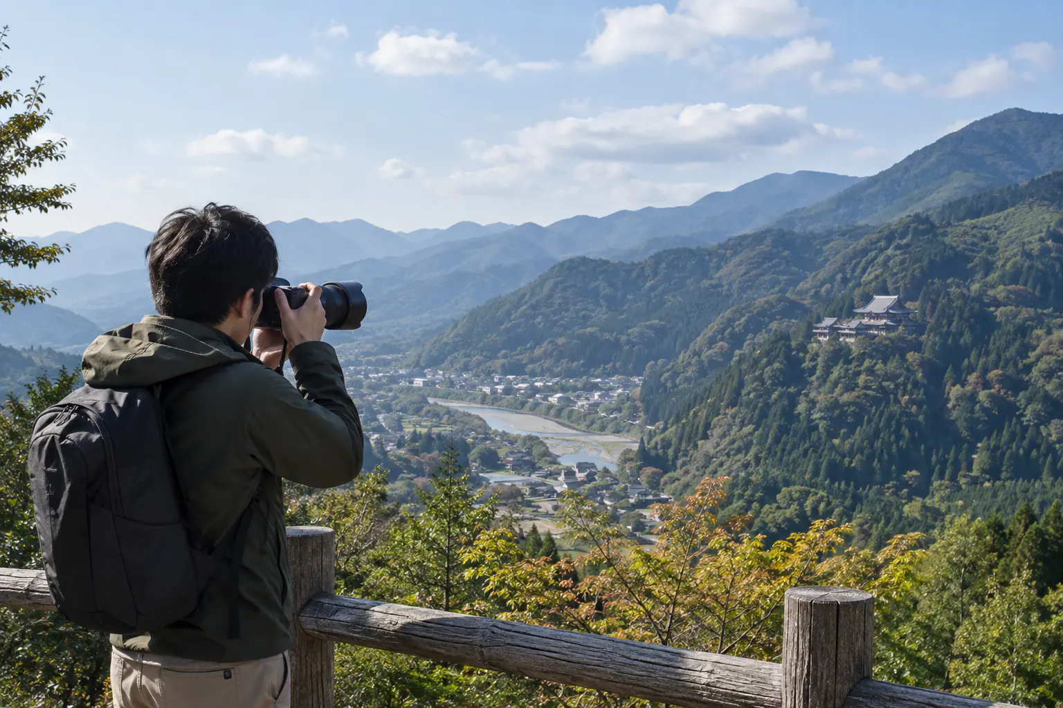 山の展望台から遠くの寺院へカメラを向ける人