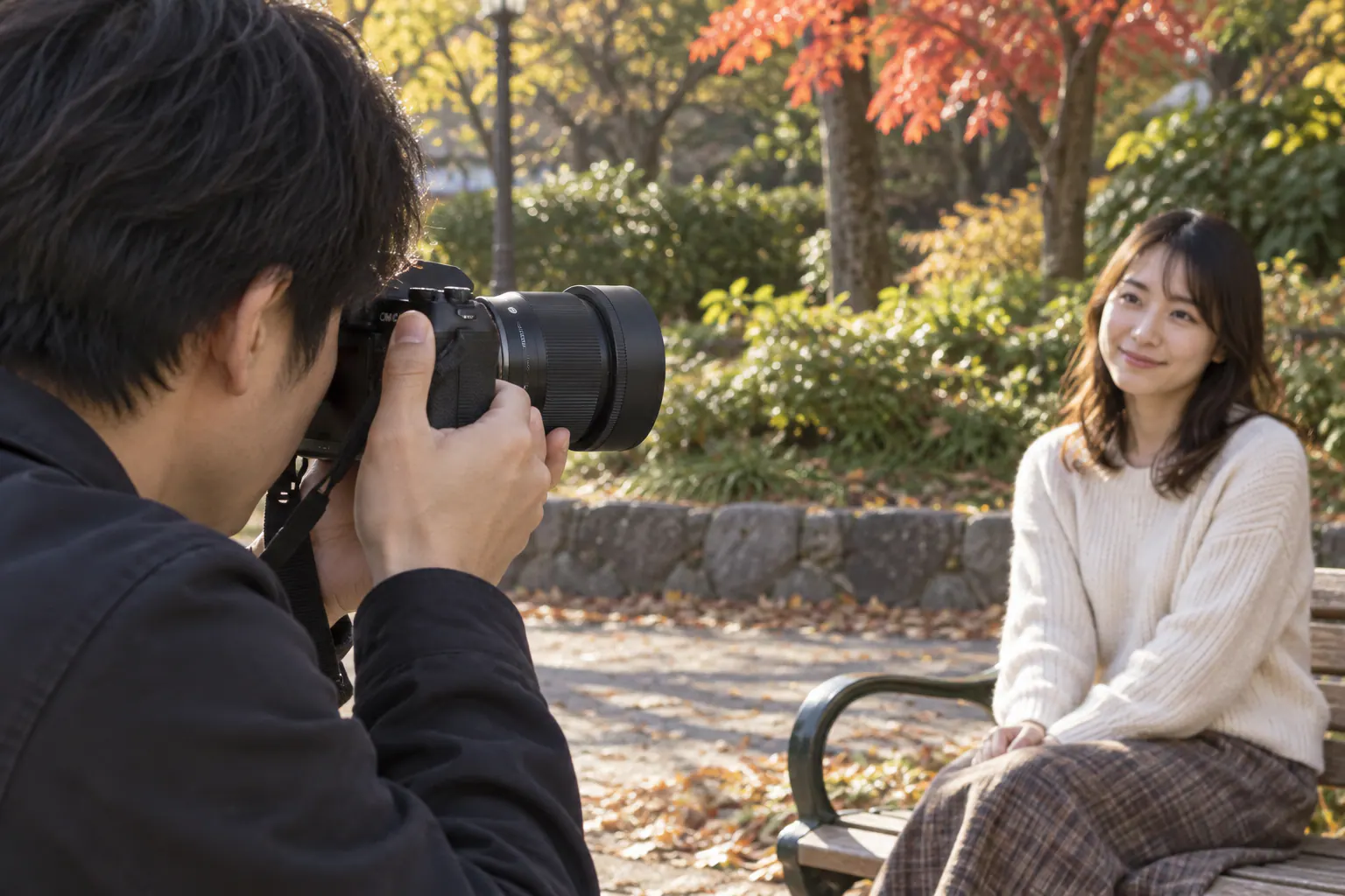 公園のベンチに座る人物へ、SIGMA 56mm F1.4を付けたカメラを向けて撮る場面