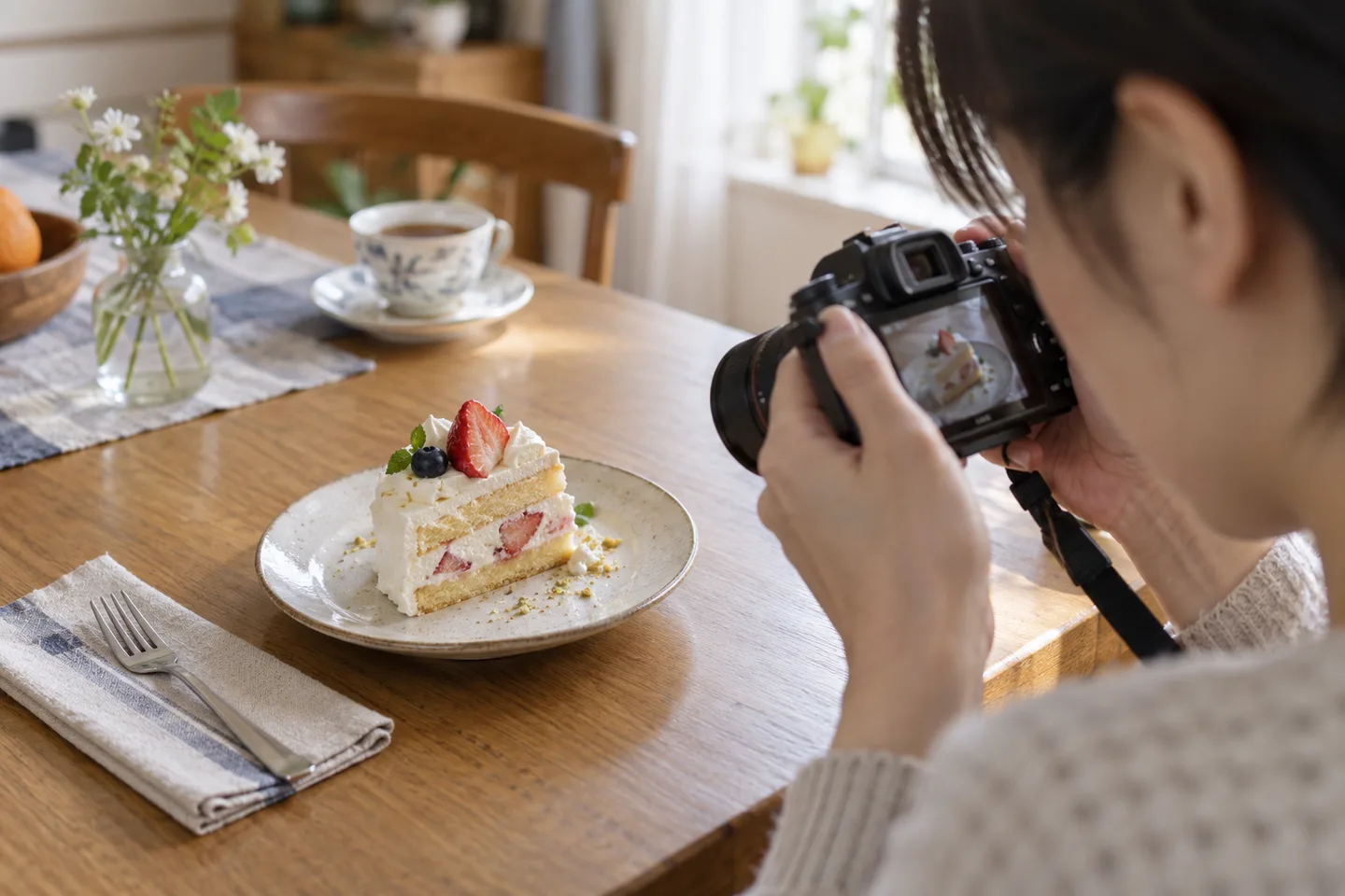 テーブルのケーキへ小さな単焦点レンズを向けて近づく撮影場面